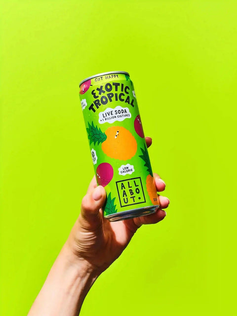 A hand holding a green can of Exotic Tropical Live Soda against a bright lime green background.
