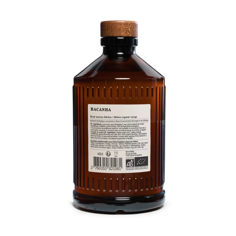 Rear view of an amber glass bottle with a ribbed texture, a wooden cap, and a white label reading 'BACANHA Real Saffron Aromatic'.