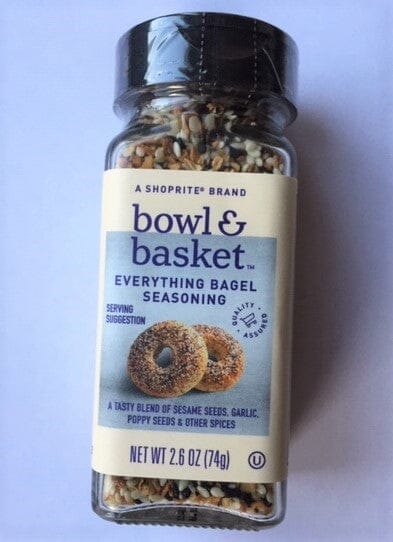 A Shoprite brand bowl & basket Everything Bagel Seasoning spice jar, showing the seasoning blend through the clear bottle against a light purple background.