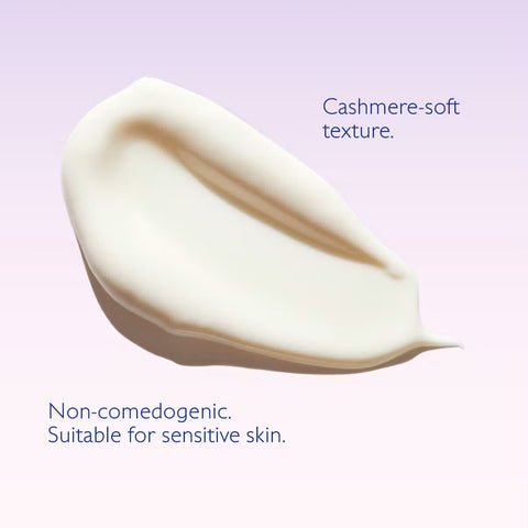 A smear of creamy off-white cosmetic cream on a soft lavender background, with text reading 'Cashmere-soft texture.' and 'Non-comedogenic.