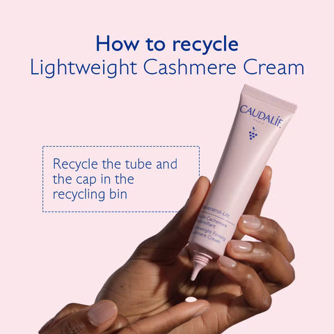 A hand holds a pale pink tube of CAUDALIF Lightweight Cashmere Cream against a light pink background with blue text explaining recycling the tube and cap.
