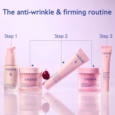 A skincare routine graphic showing four Caudalie products arranged in three steps under the headline 'The anti-wrinkle & firming routine.' The products include a serum bottle, a cream jar, a tube, and another cream jar, all in soft pink packaging on a pale lavender background with reflective surfaces.