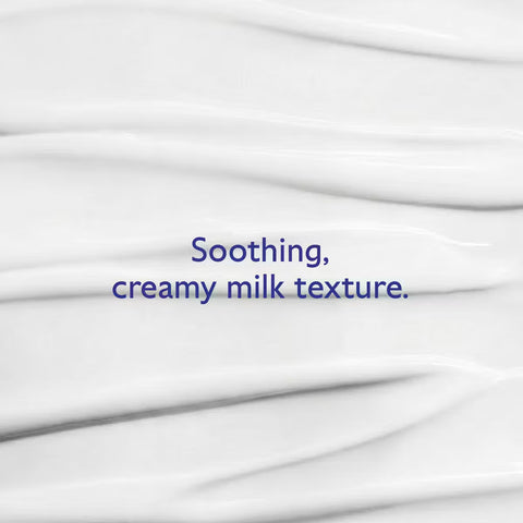 A close-up of a white creamy product with a smooth, whipped texture and blue text in the center that reads, 'Soothing, creamy milk texture.'.