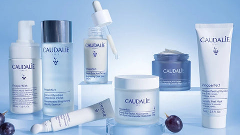 Caudalie skincare products on a blue background