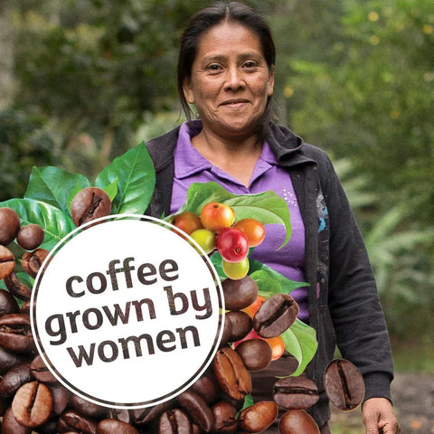 A woman standing outdoors in a lush green environment, wearing a purple shirt and dark jacket, with a large graphic overlay of coffee beans, coffee leaves, and cherries, and a circular badge that reads 'coffee grown by women'.
