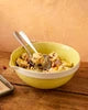 Yellow bowl with dessert on a wooden table