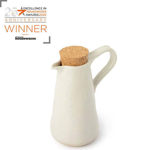 White pitcher with cork lid on a white background, featuring the Excellence in Housewares Awards 2025 text.