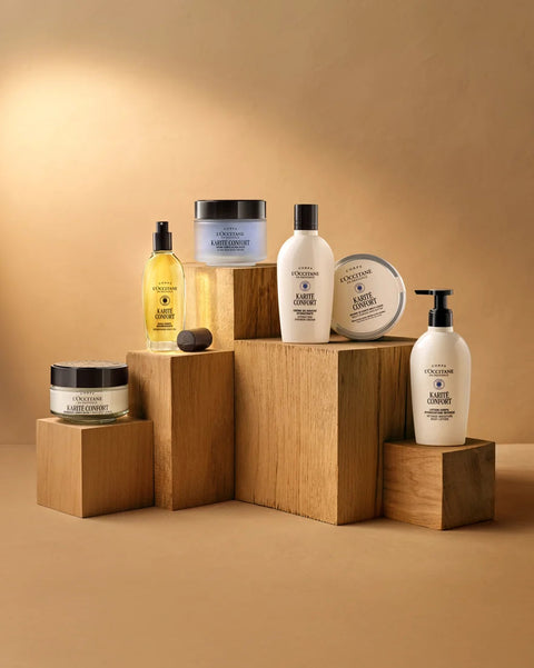 Collection of skincare products on wooden blocks against a beige background