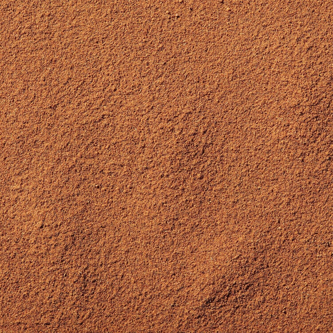 A close-up texture of fine, granular brown powder, likely pumpkin spice powder, filling the entire frame.