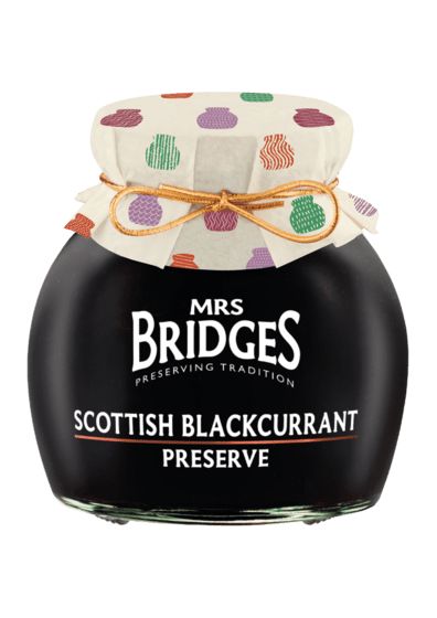 A jar of Mrs. Bridges Scottish Blackcurrant Preserve with a black glass body, white text label, and a cream fabric lid decorated with colorful cactus patterns, tied with a gold string.