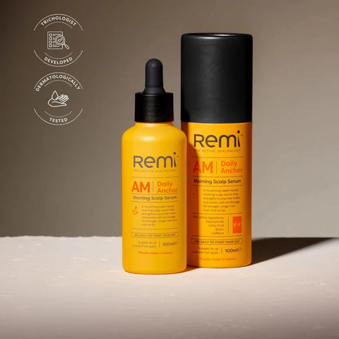 Yellow bottle and black tube of Remi AM Daily Anchor Scalp Serum on a neutral background