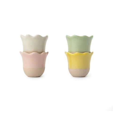 Two ceramic cups with wavy edges in pastel colors on a white background